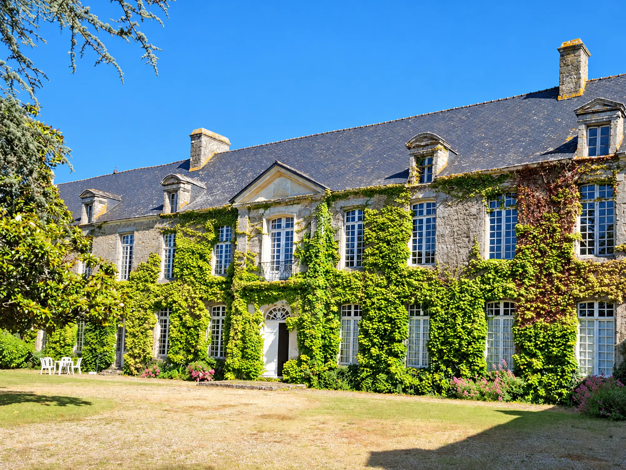 Façade en pierre couverte de végétation au Manoir de Kercadio à Erdeven