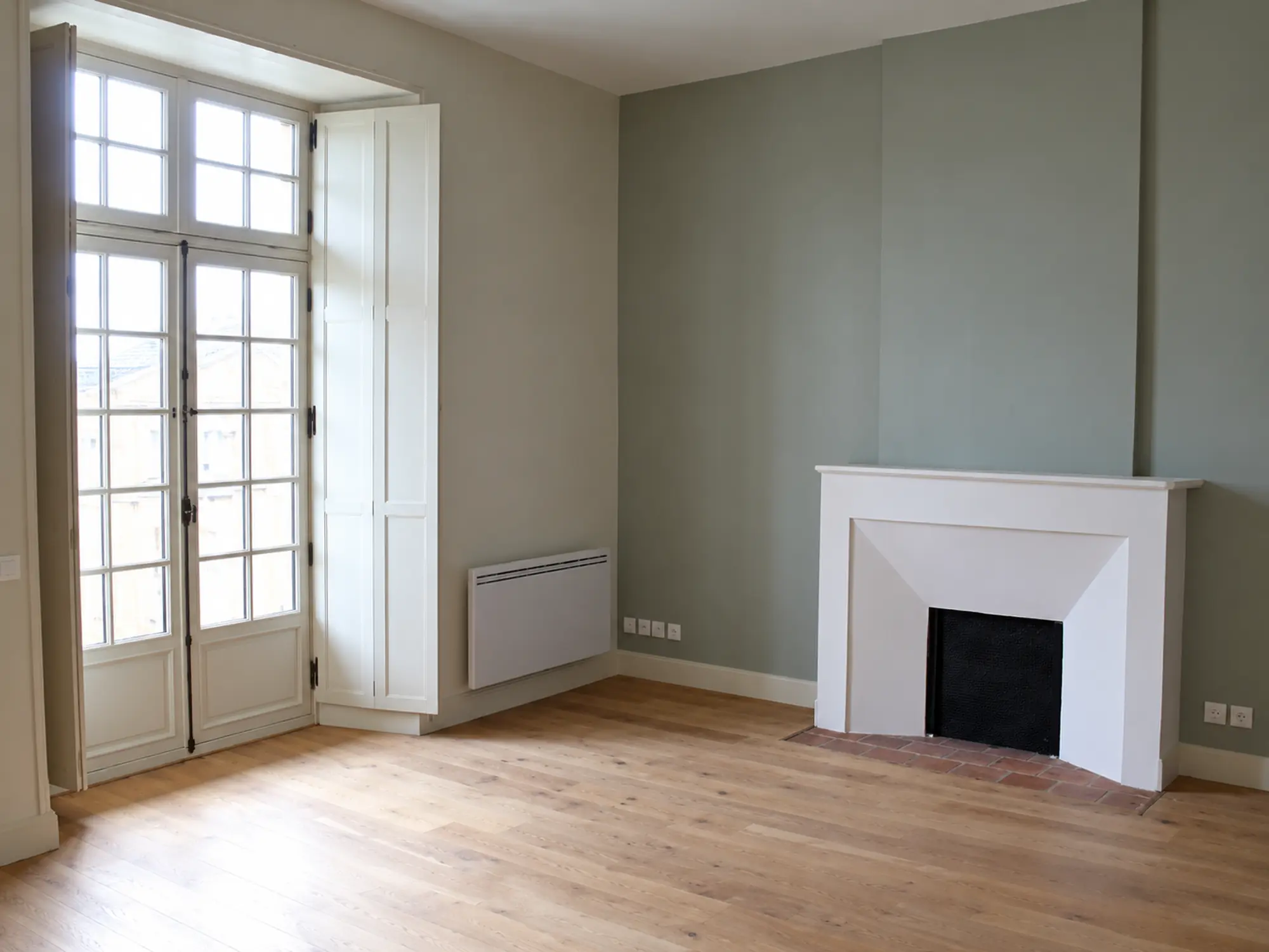 Pièce vide avec cheminée et fenêtre dans l’Hôtel de Lambert à Périgueux